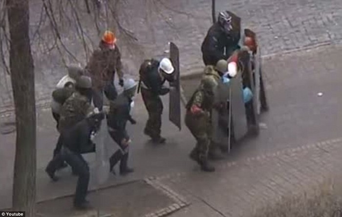 Một nhóm người biểu tình đi sau lá chắn trước khi bị bắn.