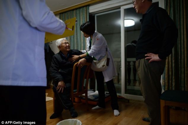 Các nhân viên y tế đến thăm phòng khách sạn của ông Ma Jong-Tae (giữa), một trong những người Hàn Quốc được lựa chọn để tham dự cuộc đoàn tụ gia đình với miền Bắc.