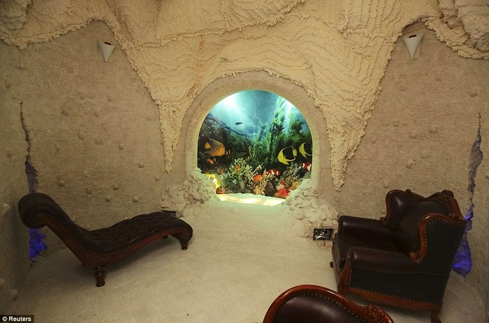 Ghế salon bên trong căn phòng trang trí giống như hang động có bể cá độc đáo.