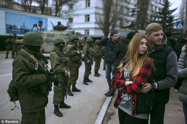 Người dân Ukraina trước một hàng rào tay súng tại Crimea.
