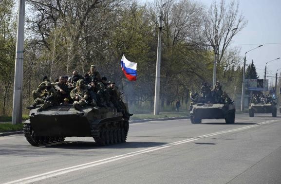 Ảnh: Đội quân mặt nạ có vũ trang lái xe bọc thép mang cờ Nga di chuyển bên ngoài thị trấn Kramatorsk hôm 16/4.