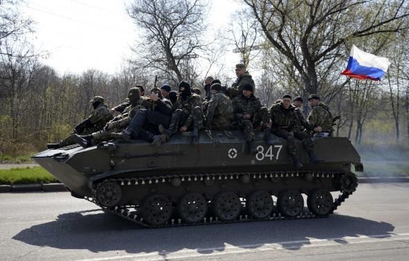 Ảnh: Đội quân mặt nạ có vũ trang lái xe bọc thép mang cờ Nga di chuyển bên ngoài thị trấn Kramatorsk hôm 16/4.