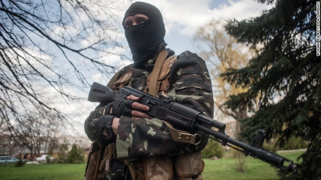 Một tay súng đeo mặt nạ đứng gần xe tăng trong Slaviansk.
