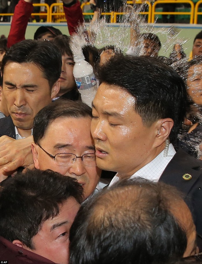 Các vệ sĩ bảo vệ Thủ tướng Hàn Quốc khi ông bị tấn công bằng chai nước.