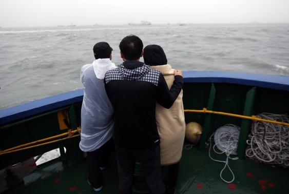 Một cặp vợ chồng đứng trên tàu nhìn ra hiện trường vụ chìm phà.