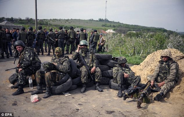 Binh sĩ Ukraine nghỉ ngơi tại một trạm kiểm soát cách không xa trung tâm Slaviansk. Lực lượng an ninh Ukraine cho biết, họ đã phải chiến đấu với những người đàn ông quân sự có kỹ thuật cao trong thành phố.