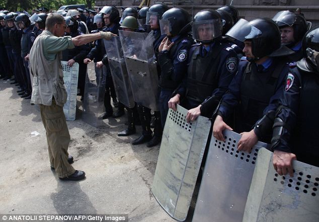 Một người biểu tình ủng hộ Nga tranh luận với cảnh sát bảo vệ tòa nhà công đoàn bị đốt cháy.
