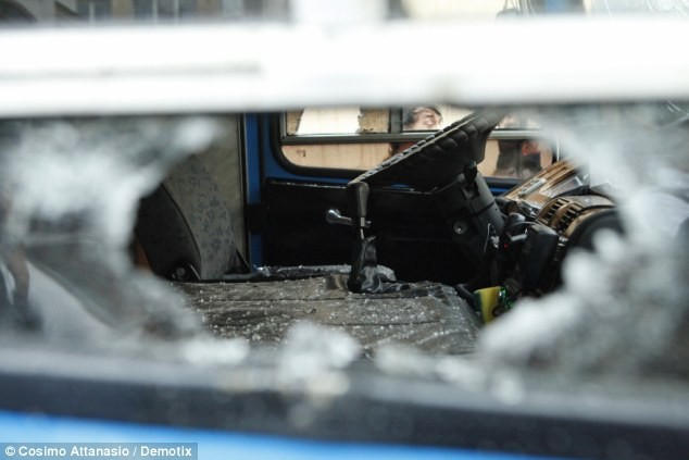 Xe cảnh sát bị người biểu tình giận dữ phá vỡ cửa kính.
