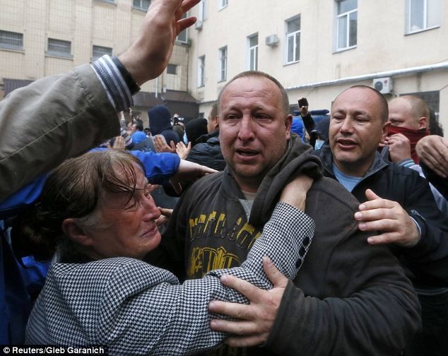 Một phụ nữ bật khóc khi đón thân nhân được giải phóng khỏi đồn cảnh sát.