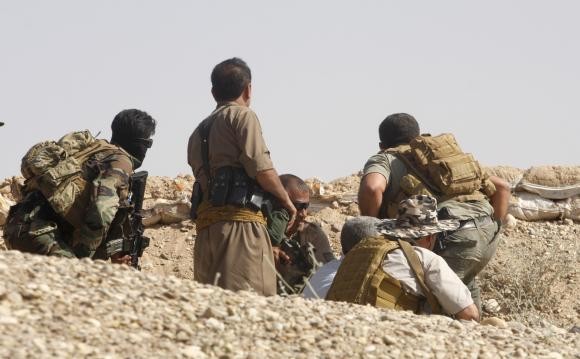 Các chiến binh người Kurd ẩn nấp trong một trận chiến với các chiến binh Sunni hôm 17/6.