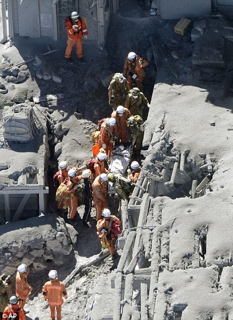 Các nhân viên cứu hộ đưa một thi thể ra ngoài ngôi nhà trên núi.