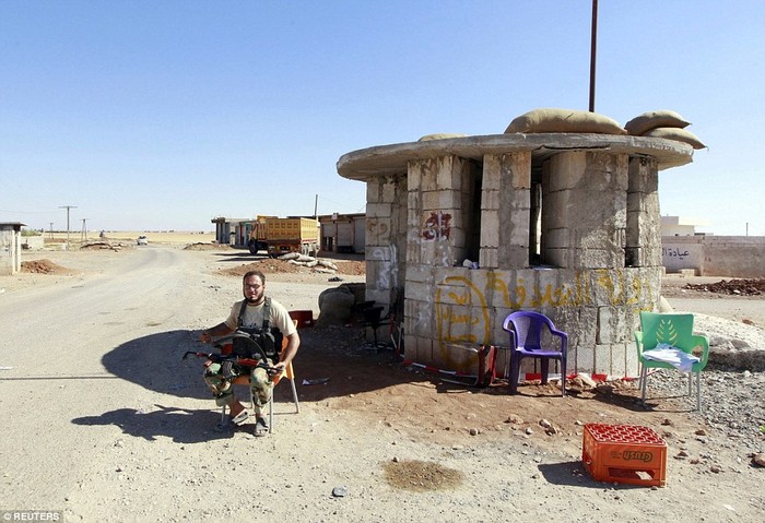 Một kẻ khủng bố IS ngồi ở trạm kiểm soát trước đó do người Kurd nắm giữ.