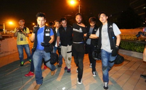 Tsang bị nhóm cảnh sát dẫn đi trước khi bị tấn công.