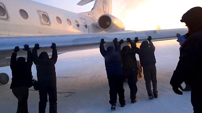 Hành khách chung tay đẩy máy bay bị kẹt trong băng.