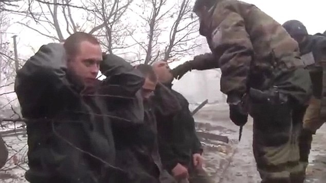 Givi nhét mảnh áo vào miệng một tù binh quân đội Ukraine.