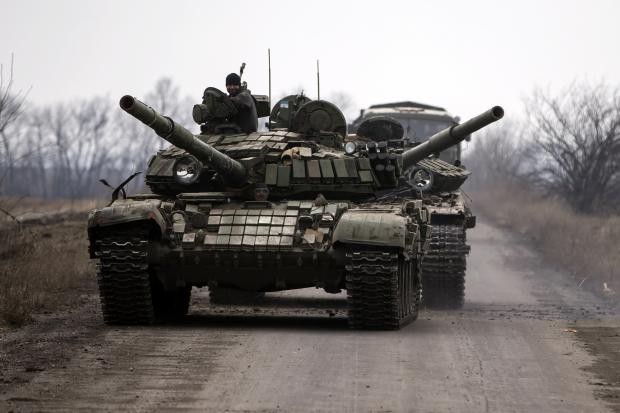 Lực lượng ly khai ủng hộ Nga di chuyển chiếc xe tăng bị hỏng trong làng Chornukhyne gần thị trấn Debaltseve, phía đông bắc Donetsk, ngày 12 tháng 3 năm 2015. Ảnh Reuters.