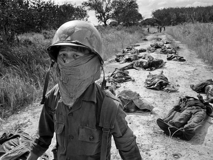Một người lính dùng khăn che ngăn mùi tử thi xông lên từ các thi thể những người lính Việt Nam và Mỹ thiệt mạng trong cuộc đụng độ gần Sài Gòn. Ảnh của phóng viên ảnh nổi tiếng người Đức Horst Faas.