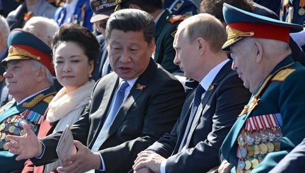 Vợ chồng nhà lãnh đạo Trung Quốc Tập Cận Bình ngồi cạnh Tổng thống Putin trên khán đài.