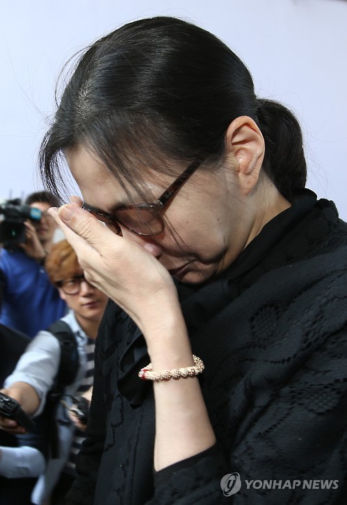 Bà Cho Huyn-ah cúi và che mặt, im lặng khi rời tòa án.