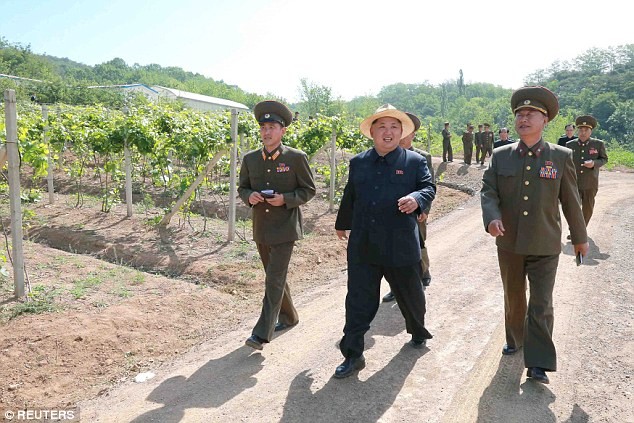 Ông Kim Jong-un cười rất tươi khi đi trên lối vào trang trại.
