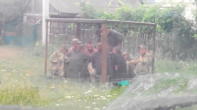 Binh sĩ Ukraine bị nhốt trong chiếc lồng chật chội không thể đứng thẳng lưng. Ảnh Daily Mail.