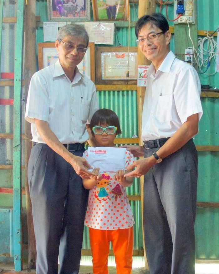 Thầy Trương Kỉnh Nhơn trong một lần trao tiền cho một em học sinh (Ảnh nhân vật cung cấp)