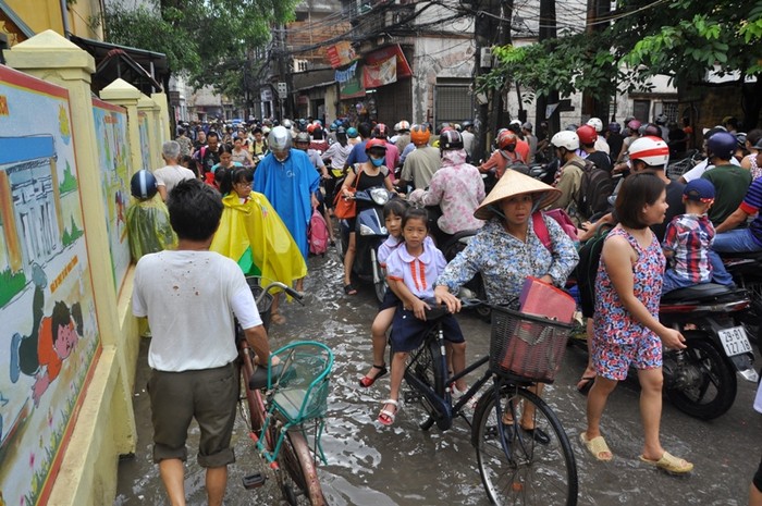 Do đường bị ngập nước nên các phương tiện qua lại tại khu vực phố Trần Cung đoạn qua Trường tiểu học Cổ Nhuế 2B gặp nhiều khó khăn, các phương tiện di chuyển chậm.