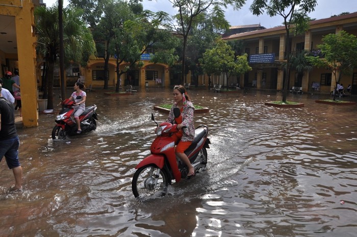 Sân trường nước ngập sâu tới 10 - 20 cm, nhiều phụ huynh đi xe máy vào thẳng sân trường để không phải lội nước