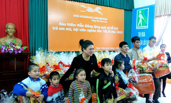 Bà Đỗ Thị Kim Liên - Lãnh sự danh dự Nam Phi tại TP HCM tặng quà và chụp ảnh lưu niệm cùng trẻ em khiếm thị tại Thừa Thiên Huế. Ảnh: Trần Thi