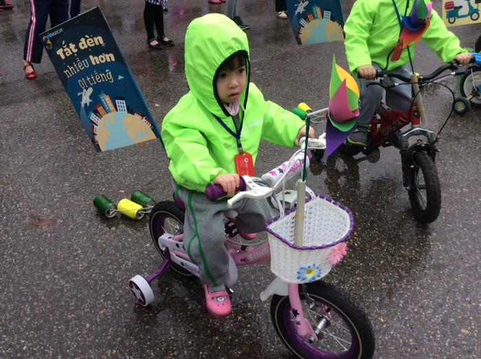 Các bé sẽ cùng đạp xe với những lá cờ mang thông điệp bảo vệ Trái Đất được gắn đằng sau. Ảnh: Hồng Nhung