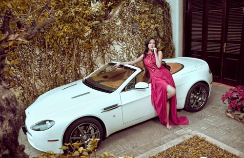 Người mẫu diện chiếc váy hồng dịu dàng bên Vantage Roadster màu trắng, hai vẻ đẹp cùng tỏa sáng.