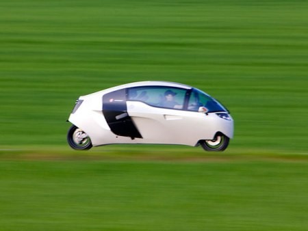 Với thiết kế mui kín, Mono Tracer có hình dáng giống ô tô hơn là xe máy. Xe có hai bánh chính và hai bánh phụ có nhiệm vụ đỡ xe khi vào cua. Chiếc xe có giá bán khoảng 75.000 USD. Nhờ 2 bánh phụ, xe có thể nghiêng góc tới 52 độ khi ôm cua.