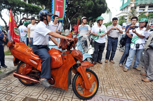 Chiếc xe máy làm bằng gỗ trong vòng vây của nhiều người dân tại lễ hội xe cổ trong khuôn khổ Festival biển Nha Trang 2011 đang diễn ra.