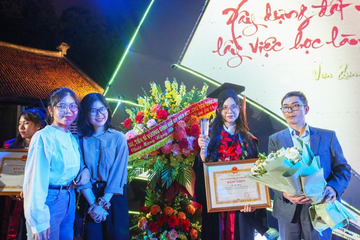Lê Thị Thùy (nhận bằng khen) cùng bố và hai chị em sinh ba của mình tại Lễ tuyên dương Thủ khoa xuất sắc tốt nghiệp các trường đại học, học viện trên địa bàn thành phố Hà Nội năm 2022 (Ảnh: NVCC).