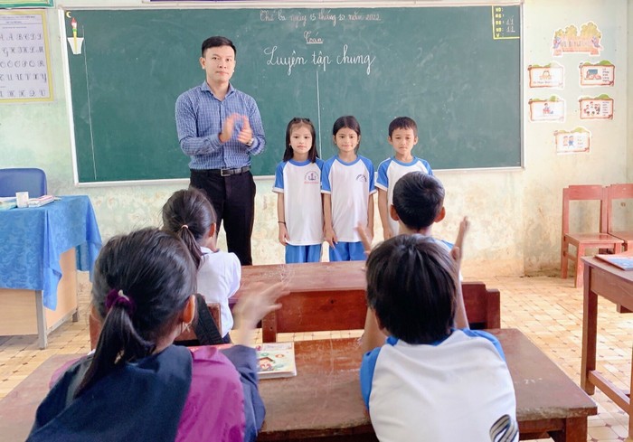 Thầy giáo Trần Lê Minh Chiến cùng học sinh Trường Phổ thông Dân tộc bán trú Tiểu học và Trung học cơ sở Sơn Màu (Ảnh: NVCC).