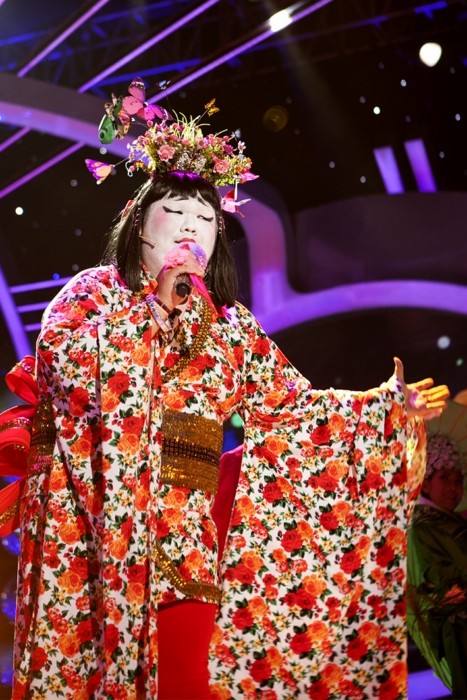Anh xuất hiện trong bộ trang phục Kimono màu sắc với một “khu vườn thu nhỏ” ngay trên đầu. Phong cách trang điểm rất ấn tượng với đôi môi đỏ nổi bật khiến nhiều khán giả không thể nén được sự thích thú.