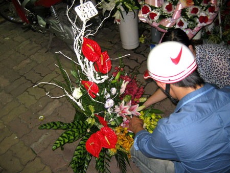 Một khách hàng đang chuẩn bị "rinh" lẵng hoa giá 1 triệu đồng tại shop hoa Kinh Đô trên phố Huế.