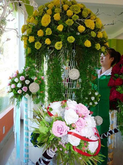 Giỏ hoa hồng sấy khô có giá 15 triệu đồng đang được nhân viên trang trí làm đẹp. Đây là loại hoa tươi Đà Lạt sau khi thu hoạch được công ty này sấy khô bằng công nghệ sinh học Nhật Bản. Trong điều kiện bình thường, hoa tươi sấy khô có tuổi thọ kéo dài từ 3 -5 năm