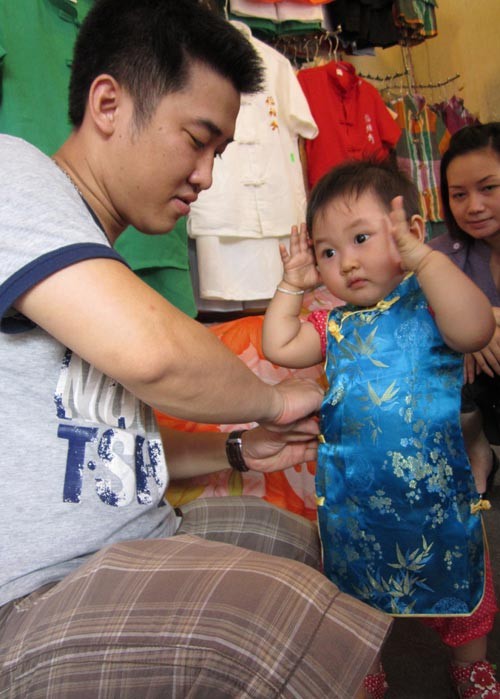 Một em bé được bố diện cho bộ đồ mới ngay tại hội chợ