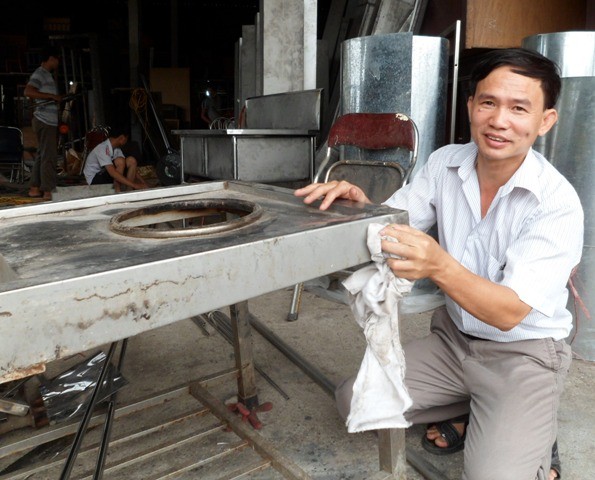 "Vua chợ đồ cũ" Nguyễn Văn Thưởng đang lau chùi chiếc bếp inox cũ vừa mua thanh lý được. Ảnh Xuân Hải.