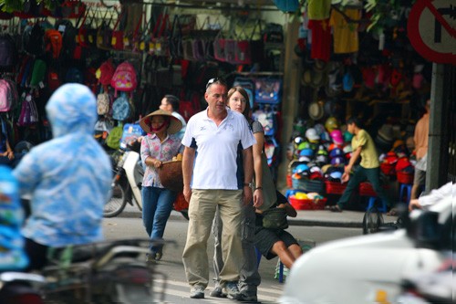 Hai khách nước ngoài đi bộ đến giữa đường Hàng Bông (quận Hoàn Kiếm, Hà Nội) đứng lại và nắm tay nhau thật chặt do các phương tiện khác không chịu nhường đường hay đi chậm lại.