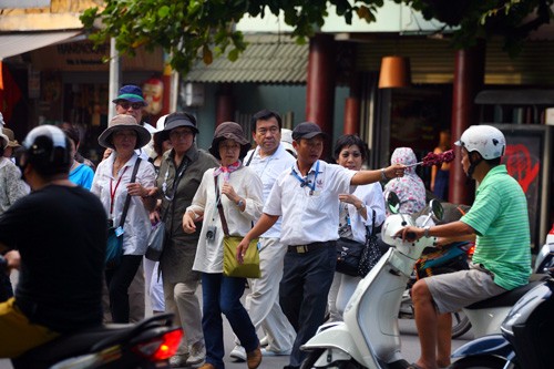 Hướng dẫn viên du lịch vẫy cờ xin đường, trong khi đó đoàn khách người Hàn Quốc "co rúm" người.