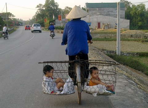 Hai đứa trẻ ngồi trong rọ sắt. Ảnh do độc giả Đào Hồng Phong chia sẻ.
