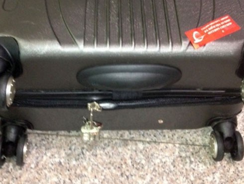 Vali bị phá khóa. Thông thường 2 kéo khóa của vali được kéo và khóa lại. Tuy nhiên, trong ảnh chỉ còn một kéo khóa với ổ khóa lơ lửng. Ảnh: Hành khách cung cấp