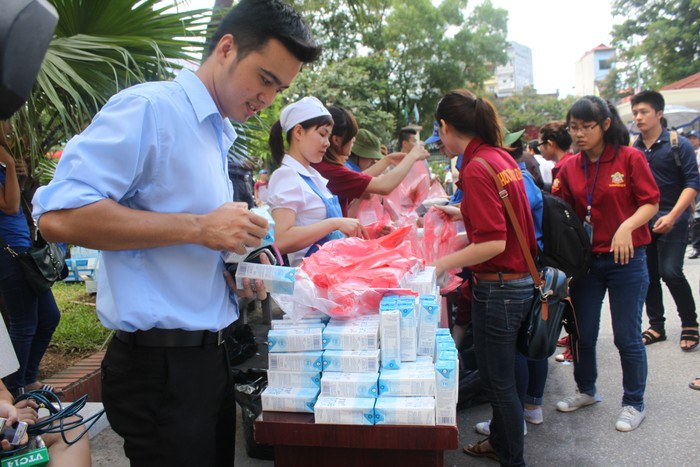 Nhân viên TH true MILK và các bạn tình nguyện trong nhóm Hương sen đại bi chùa Hưng Khánh chuẩn bị suất cơm trưa và sữa cho thí sinh và người nhà.