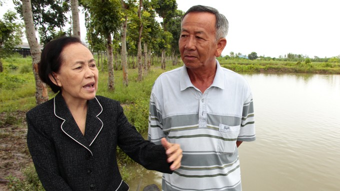 Bà Trần Ngọc Sương kiểm tra tình hình nuôi cá tại ao nuôi của công ty - Ảnh: Chí Quốc