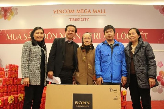 Anh Nguyễn Khắc Vinh (áo xanh thứ 2 từ phải sang) cùng gia đình vui nhận quà tặng là một chiếc Tivi Sony Bravia 42 inch tại VMM Times City.