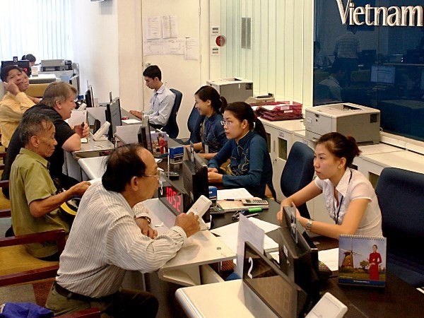 Khách hàng mua vé tại đại lý vé máy bay của Vietnam Airlines. (Ảnh: Huy Hùng/TTXVN)