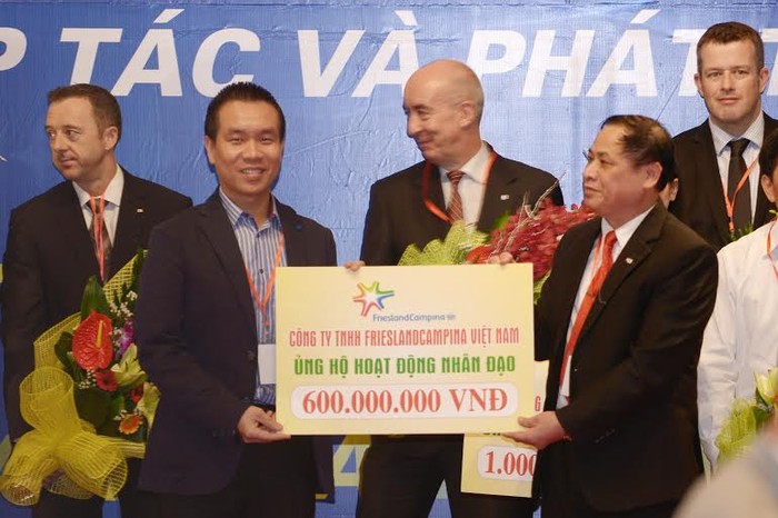 Đại diện FrieslandCampina Việt Nam trao tặng bảng tượng trưng 60 c0n bò giống cho Hội Chữ thập đỏ Việt Nam.