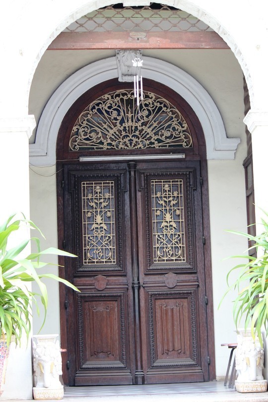Lối vào có hai lớp cửa, bên trong cửa gỗ và bên ngoài cửa cuốn sắt được đẩy lên. Đây là một trong những nét đặc trưng kiến trúc Pháp những năm đầu thế kỉ XX.